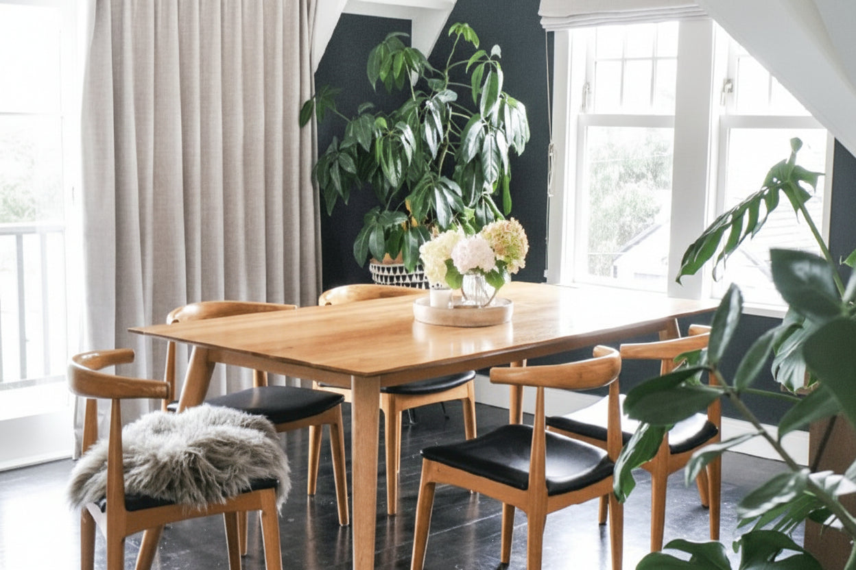 Dining room with wooden table and chairs, including an 'elbow chair'.