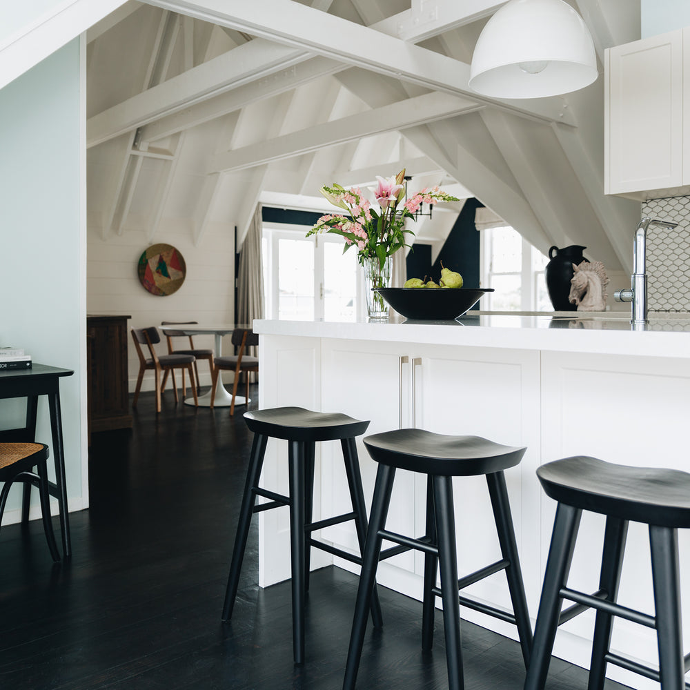 
                      
                        Modern kitchen with Fuji bar stools featuring contoured seats and A-line legs, blending rustic and modern styles with retro flair.
                      
                    