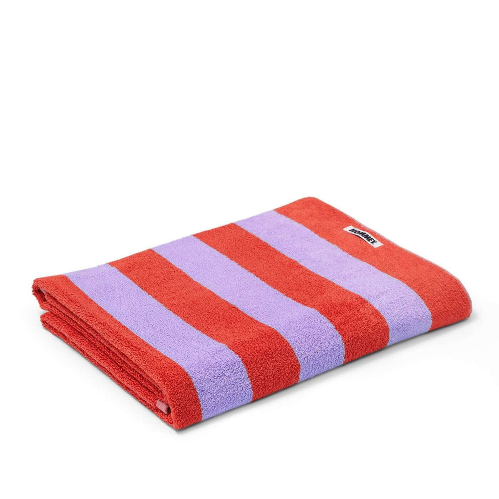 Grapefruit striped beach bath towel with luxurious feel and high absorbency by Hommey, in red and lavender hues, folded neatly.