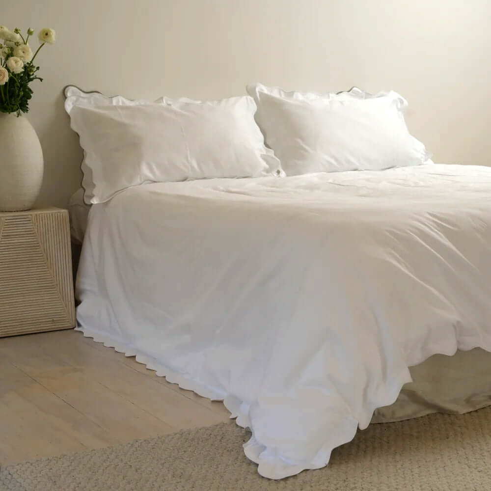 Elegantly embroidered Celine duvet set in soft 750-thread count cotton with scallop edges, adding sophistication to a bedroom.