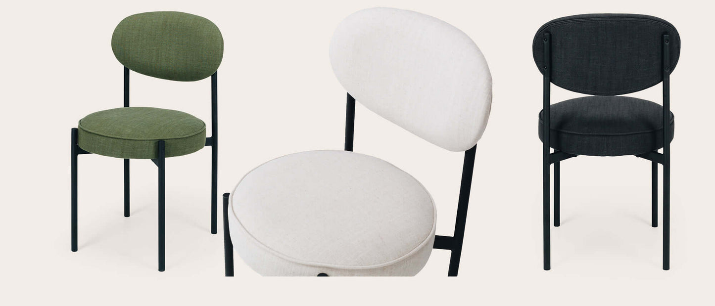 Modern upholstered chairs in green, white, and black with sleek black legs.