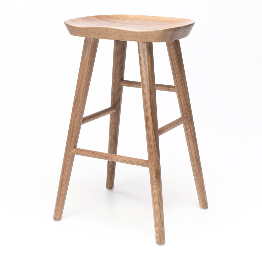 Fuji bar stool with natural woodgrain, contoured seat, and A-line legs, inspired by Swiss tractor seat for modern rustic decor.