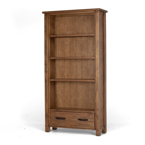 Solid pine bookcase with four open display cavities and one drawer with black metal handles, on a white background, shown from an angled view